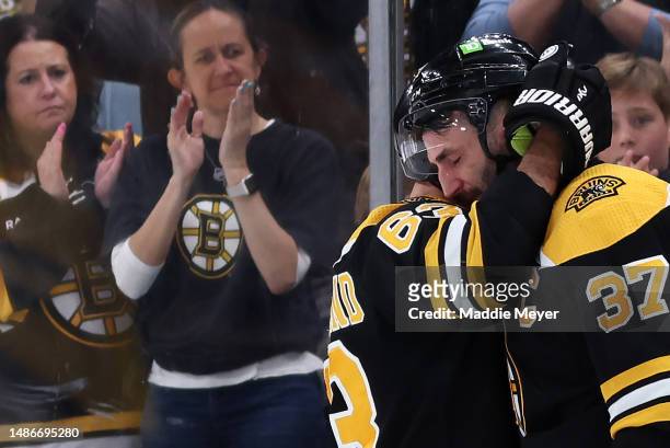 Patrice Bergeron of the Boston Bruins hugs Brad Marchand before exiting the ice after Florida Panthers defeat the Bruins 4-3 in overtime of Game...