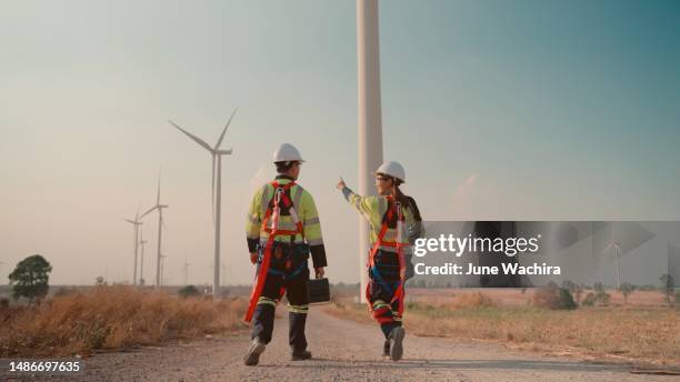 two engineer walking and checking at the natural energy wind turbine station. - construction site stock pictures, royalty-free photos & images