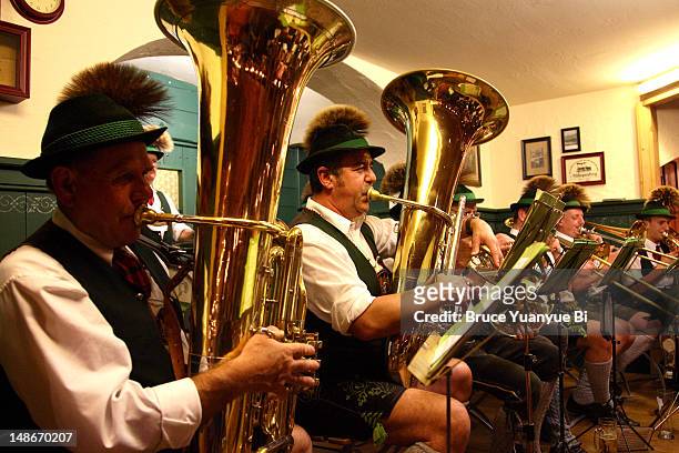 brass band in traditional bavarian clothing playing in restaurant. - brass band stock pictures, royalty-free photos & images