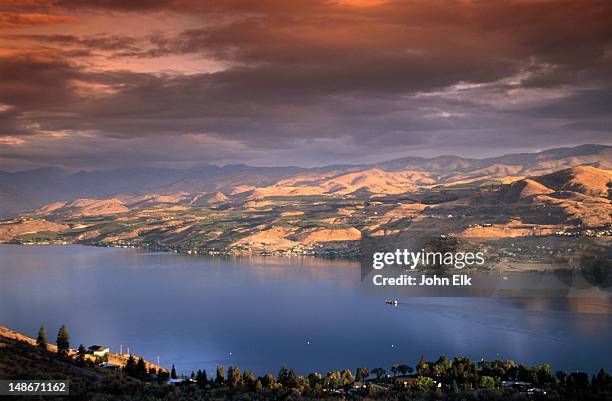 sunrise casts pastel hues over the city of chelan and the fjord-like lake chelan in the north cascades region. - lake chelan stock pictures, royalty-free photos & images