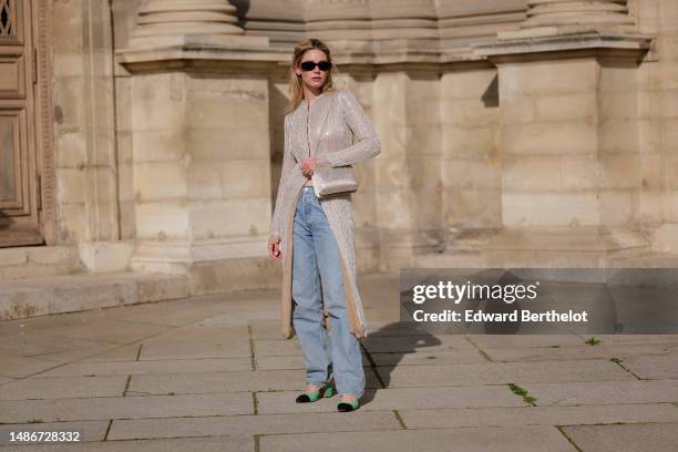 Natalia Verza wears black sunglasses from Miu Miu, crystals earrings, a beige embroidered sequins / mesh long kimono from Armani, a beige satin with...