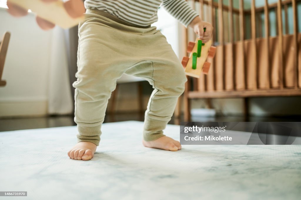 Walking, learning and growth with feet of baby in nursery for child development, hope and education. Faith, cute and trust with first steps of infant at home for for youth, childhood and support