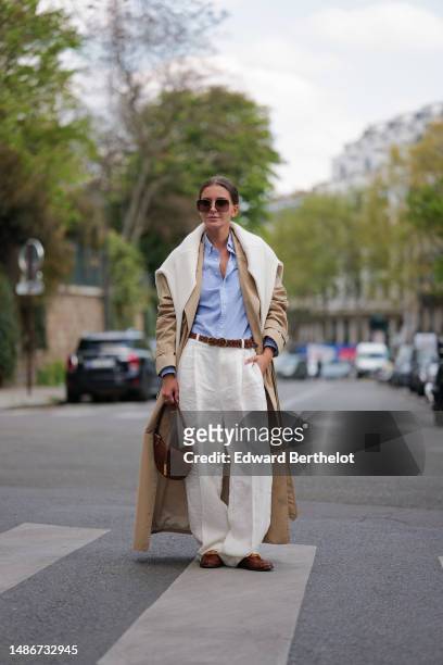 Diane Batoukina wears dark brown squared sunglasses from Dior, a pale blue cotton shirt from Ralph Lauren, a white matte large cashmere pullover from...