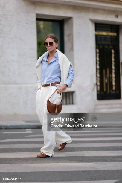 Diane Batoukina wears dark brown squared sunglasses from Dior, a pale blue cotton shirt from Ralph Lauren, a white matte large cashmere pullover from...