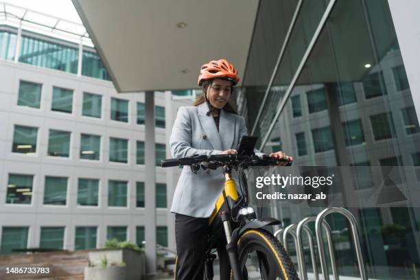 sustainable urban mobility, woman rents city bike. - bicycle parking station stock pictures, royalty-free photos & images
