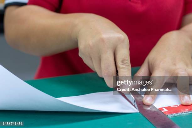 close up photo of hand use the cutter cut paper - ripped newspaper headline stock pictures, royalty-free photos & images