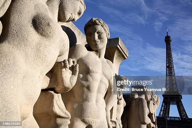 stone sculptures at base of chaillot pool with eiffel tower in background. - figura feminina imagens e fotografias de stock