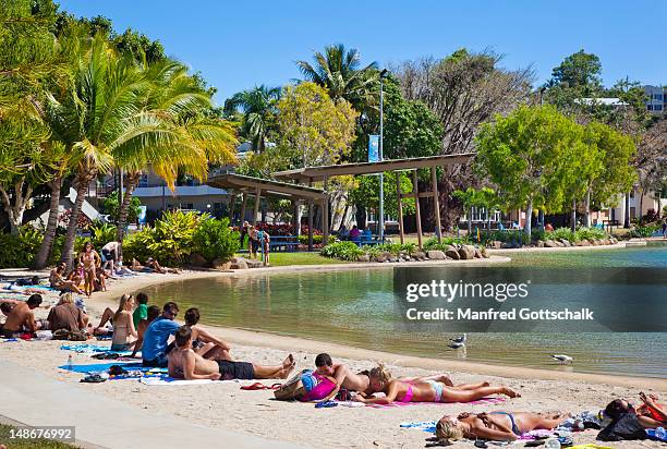 people relaxing at the airlie beach swimming lagoon. - airlie beach stock pictures, royalty-free photos & images