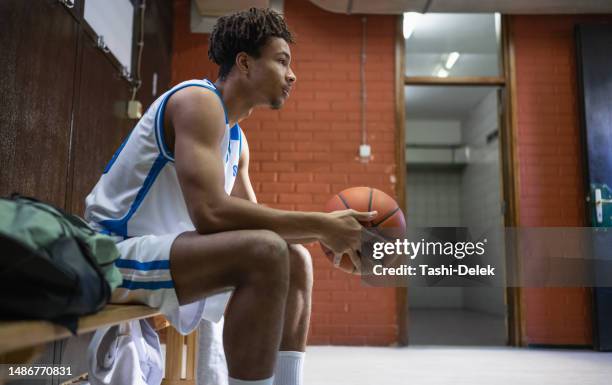 estrella masculina de baloncesto con baloncesto en el vestuario - competición de baloncesto fotografías e imágenes de stock
