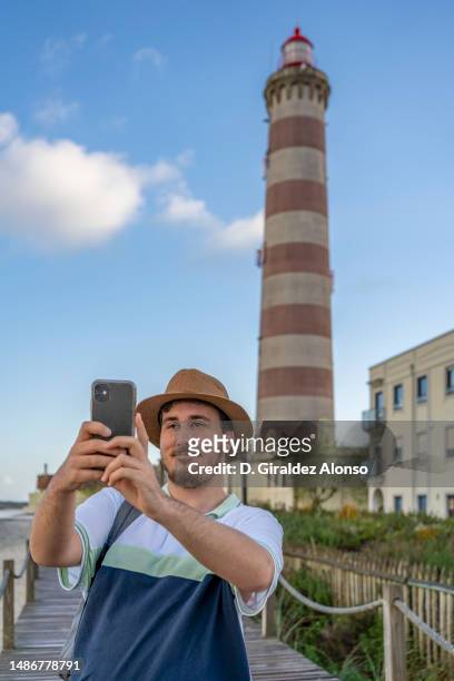 man making selfie in front of barra lighthouse, aveiro, portugal. - aveiro district stockfoto's en -beelden