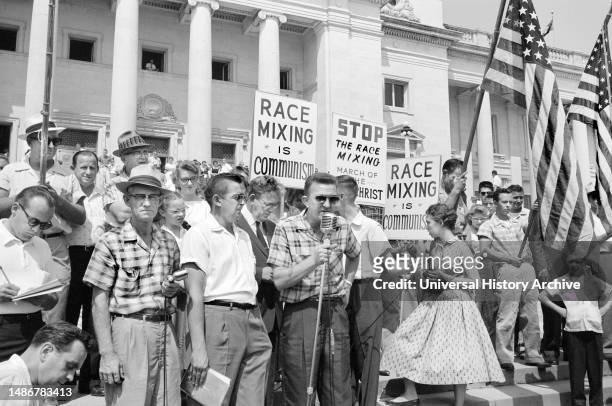 Crowd at Arkansas State Capitol protesting integration of Central High School, with signs reading "Race mixing is Communism" and "Stop the race...