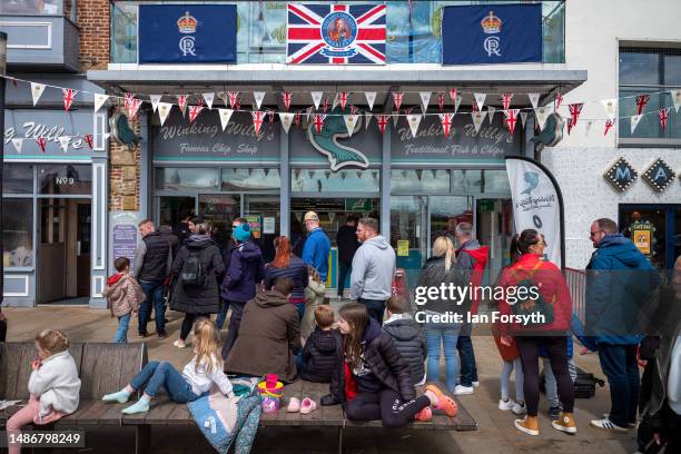 Large queue forms at a food shop as people visit Scarborough on May Day bank holiday on May 01, 2023 in Scarborough, England. The Early May Bank...