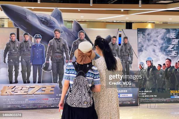 Pedestrians view a poster of film 'Born to Fly' at a cinema during the May Day holiday on May 1, 2023 in Beijing, China.