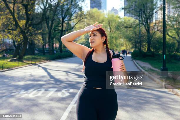 woman jogging in central park - active in new york stock pictures, royalty-free photos & images