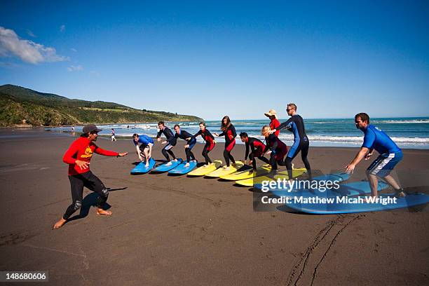 raglan surf shool and mojo surf school instructers give their surf students pointers on how to improve. - mojo stock pictures, royalty-free photos & images