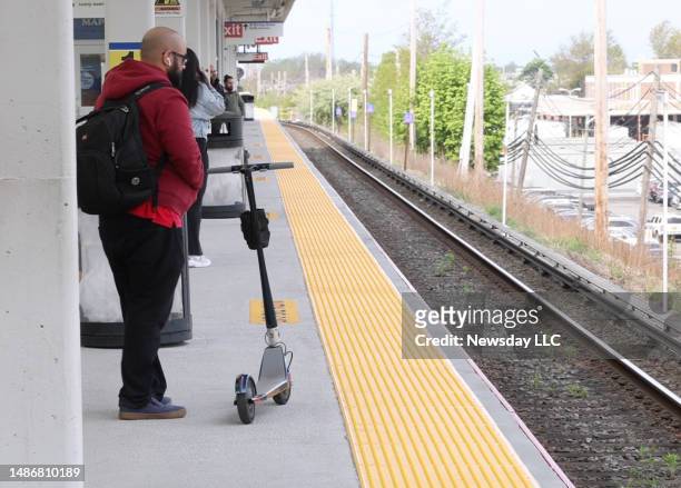 Commuter waits on the platform of the LIRR with his electric scooter on April 27, 2023 in Hicksville, New York.