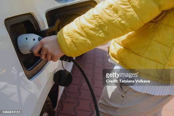 unrecognizable woman charging her car - electric car home stock pictures, royalty-free photos & images