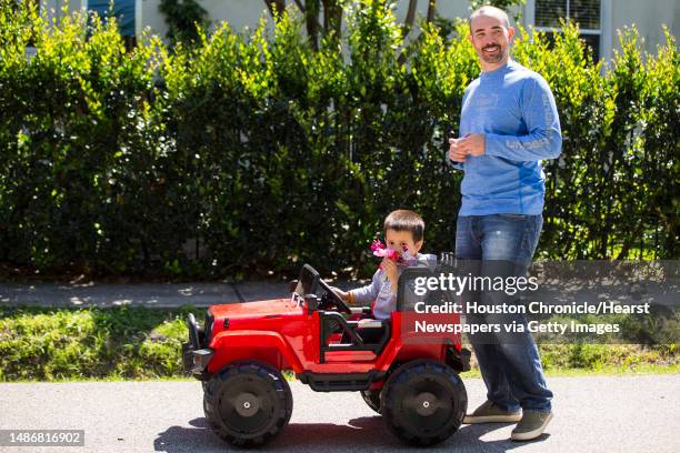 Travis Oglesby smiles after art dealer Hiram Butler gave him the a bunch of sweet pea blossoms as he walked past Butler's house, with his son, Finn,...