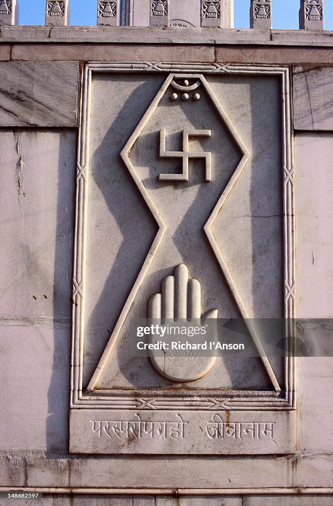 The swastika and open palm carved on the walls of the Digambara Jain temple. The swastika symbol is second only to the Om in Hindu divinity. The word swastika means auspicious in the Sanskrit language.