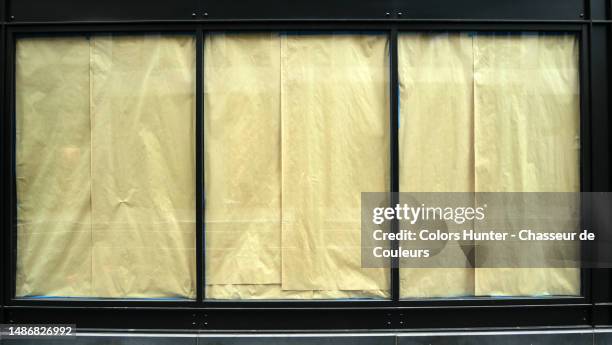 large sheets of brown paper hide the window of a closed store in manhattan, new york, usa - façade boutique photos et images de collection