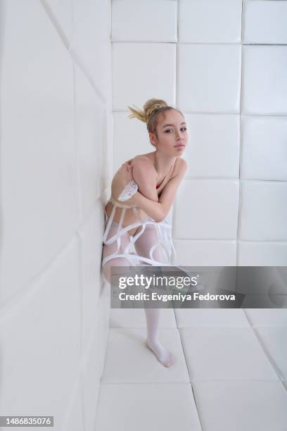 portrait of a girl in a bodysuit near the soft wall of a psychiatric ward - mockup magazine fotografías e imágenes de stock