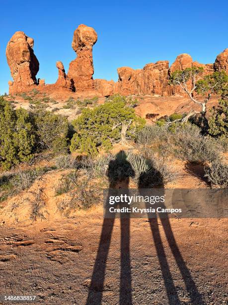 shadow of a hikers couple on the desert floor - balanced rock arches national park stock pictures, royalty-free photos & images