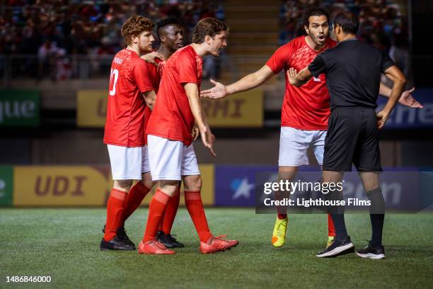 soccer players angrily argue with referee as he motions for them to back up - foul 個照片及圖片檔