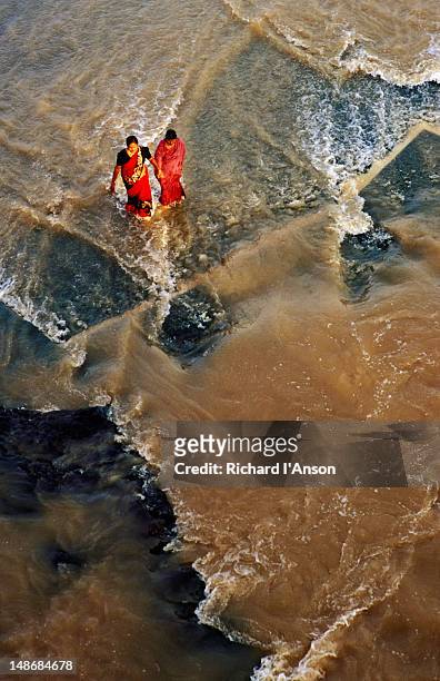 women walking in the godavari river during the khumb mela. - nashik stock pictures, royalty-free photos & images