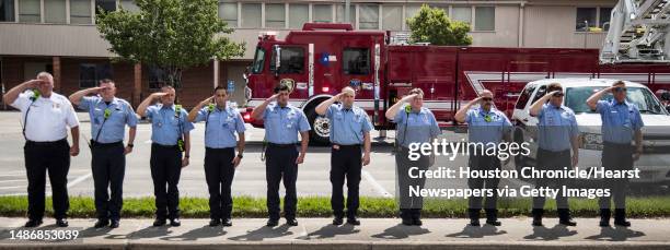 Line of Houston firefighters salute as the body of fallen Houston Police officer Jason Knox is escorted in a procession to the funeral home on...