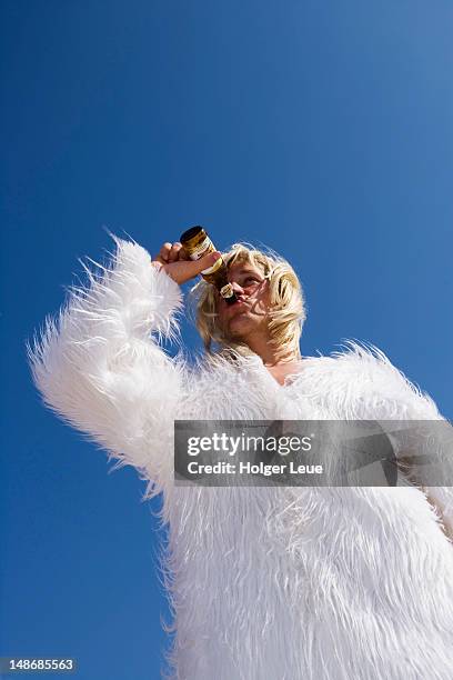 beer guzzling man in polar bear costume at el arenal beach. - tomar el sol - fotografias e filmes do acervo