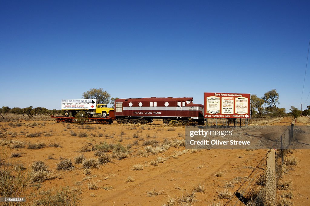 Roadside signs with old truck and train for National Road Transport Hall of Fame and Old Ghan Museum.