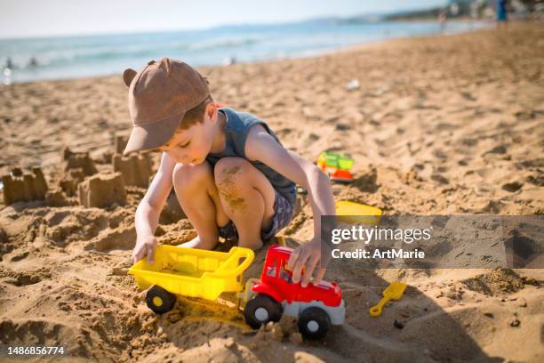 kind spielt in den sommerferien am strand - kind sandburg stock-fotos und bilder