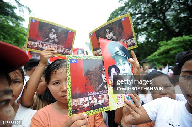 Myanmar hold pictures of independence hero General Aung San as they attend a ceremony to mark the country's 65th anniversary of Martyrs' Day at the...