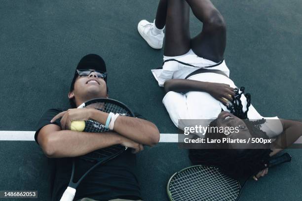 high angle view of couple lying on floor,corpus christi,texas,united states,usa - atuendo de tenis fotografías e imágenes de stock