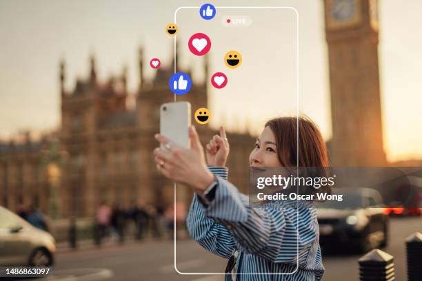 young female influencer live streaming with smartphone on social media while travelling - day uk show ストックフォトと画像