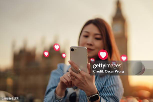 young asian woman using online dating app on smartphone in the city - applications stock pictures, royalty-free photos & images