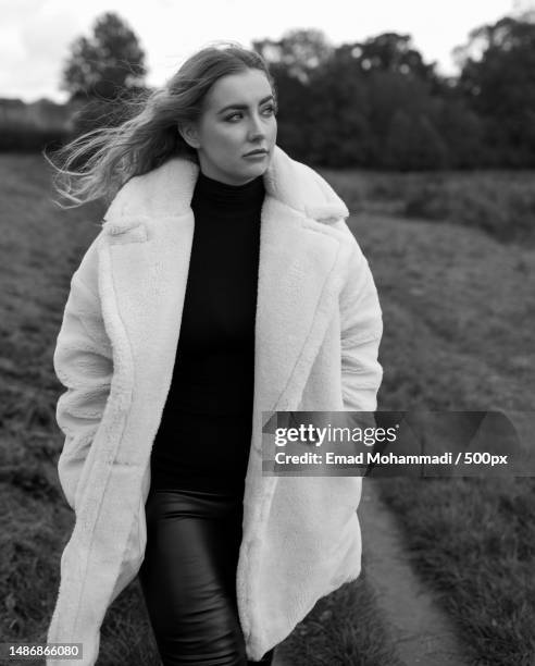 young woman standing on field,kenilworth,united kingdom,uk - editorial image stock pictures, royalty-free photos & images