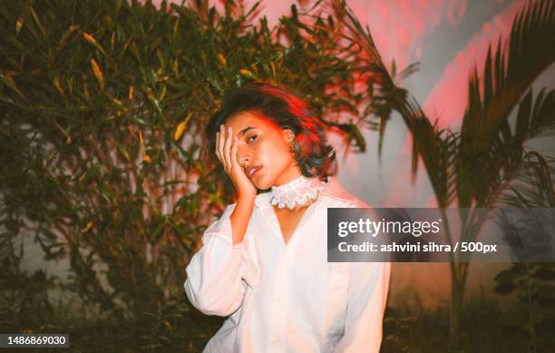 portrait of young woman standing against plants,india - editorial photography stock pictures, royalty-free photos & images