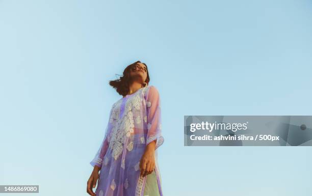 low angle view of woman standing against clear sky,india - indian saree model stock-fotos und bilder