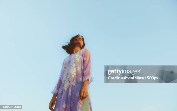 low angle view of woman standing against clear sky,india - redactioneel stockfoto's en -beelden