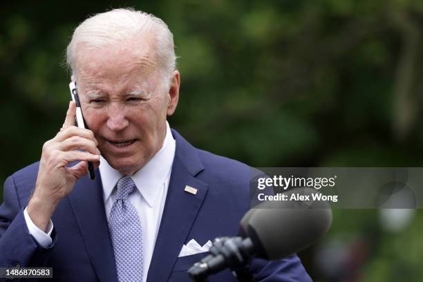 President Joe Biden talks on a cell phone during a Rose Garden event at the White House to mark National Small Business Week on May 1, 2023 in...