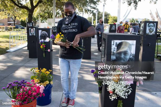 Jonathan Drake cuts flowers as he helps set up for the opening of the Say Their Names Memorial in Emancipation Park on Monday, Sept. 28, 2020 in...