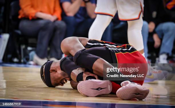Miami Heats' forward Jimmy Butler grabs his leg in pain while lying on the basketball court in the 4th quarter of Game 1 of the Eastern Conference...