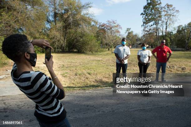 Dana Hewling, left, takes a picture with Kevan Shelton, Ayesha Shelton and Junious Williams near an empty lot they plan on developing in the Grand...
