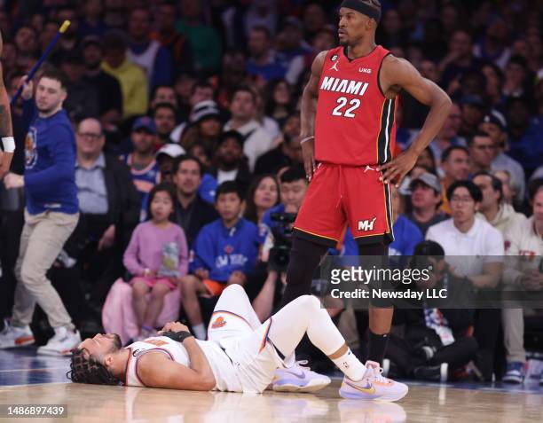 New York Knicks guard Jalen Brunson lays on his back on the court as Miami Heat forward Jimmy Butler looks on in the 3rd quarter of Game One of the...