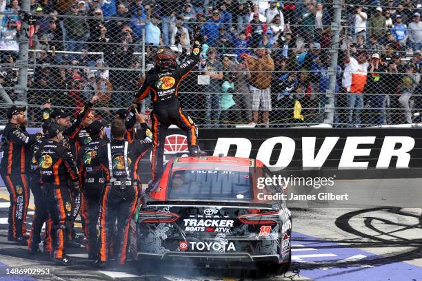 Martin Truex Jr., driver of the Bass Pro Shops Toyota, and crew celebrate after winning the NASCAR Cup Series Würth 400 at Dover International...