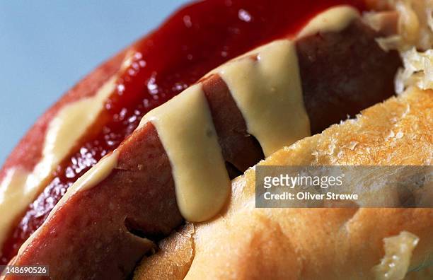 close-up of hot dog with tomato sauce and mustard. - hot dog schnellimbiss stock-fotos und bilder
