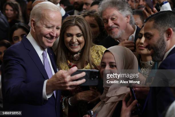 President Joe Biden takes selfies with guests during a reception celebrating Eid-al-Fitr in the East Room of the White House on May 1, 2023 in...