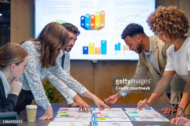 paperwork and group of peoples hands on a board room table at a business presentation or seminar. - presenting data business stock pictures, royalty-free photos & images