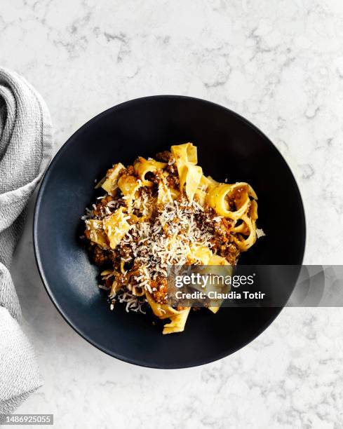 bowl of pasta (pappardelle) with tomato sauce and parmesan cheese on white background - pappardelle foto e immagini stock